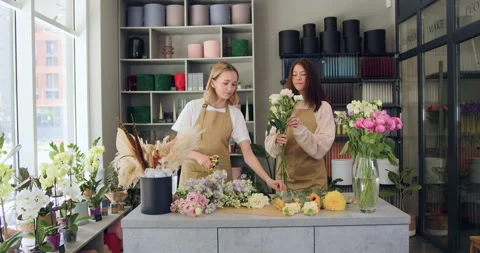 Two serious female florists working in own flower shop together. Modern flower Stock Footage 203746846