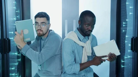 Two serious special agents aimed with digital pads sneaking into secret database Stock Footage 121224005