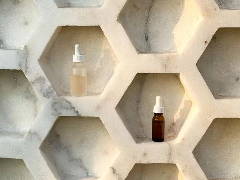 Two serums in a bottle of dark and light glass stand inside the shelf Stock Photos