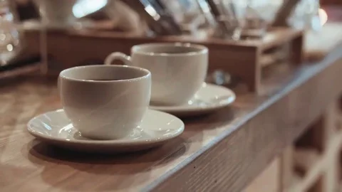 Two served glittering white cups with coffee on a soft oak counter Stock Footage 69082651