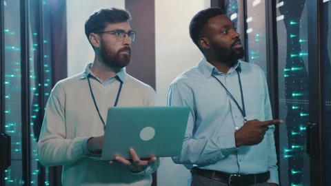 Two server administrators cooperating in cyber security server room. Multi Stock Footage 119232128