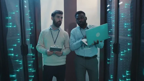 Two server engineers inspecting computer security rack corridor at data center Video stock 119081235