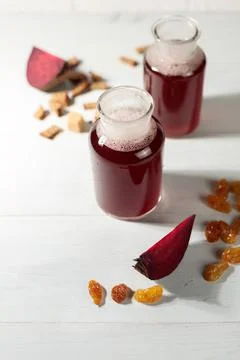 Two serving bottles with homemade beet kvass or juice. Close-up, on a light Stock Photos