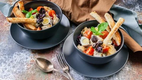 Two servings of Caesar salad with chicken, quail egg, cherry tomatoes, crouto Stock Photos
