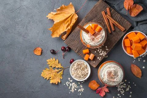 Two servings of pumpkin parfait with cream and cocoa on a dark gray background Stock Photos