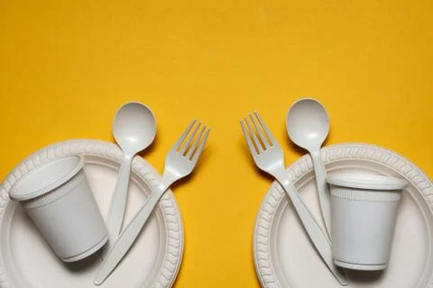 Two sets of disposable spoons, forks, plates and glasses of corn starch Stock Photos