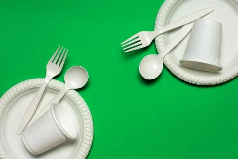 Two sets of disposable spoons, forks, plates and glasses of corn starch Foto stock