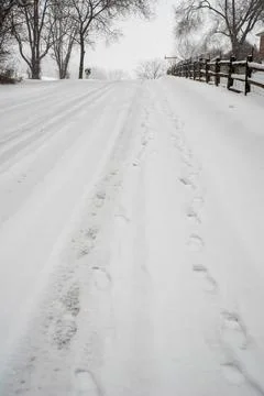 Two sets of footprints side by side on a snowy hill Stock Photos