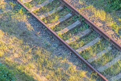 Two sets of rusty railroad tracks intersecting at an angle under a clear sky, 스톡 사진