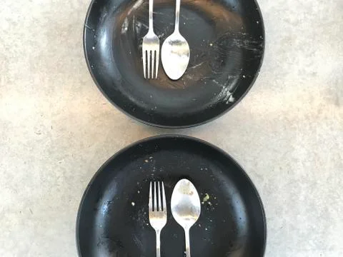 Two sets of silver spoon, fork and plate which finished eating Stock Photos