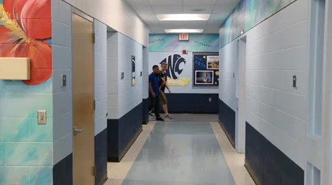 Two sets of students males and females pass in hallway men walking forward Video stock 37211482