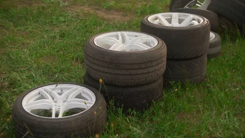 Two sets of wheels on white rims neatly folded on well-groomed green grass Video stock 128493469