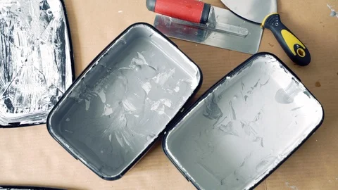Two shades of grey decorative plaster or paint and spatulas on cardboard. Stock Footage 116982079