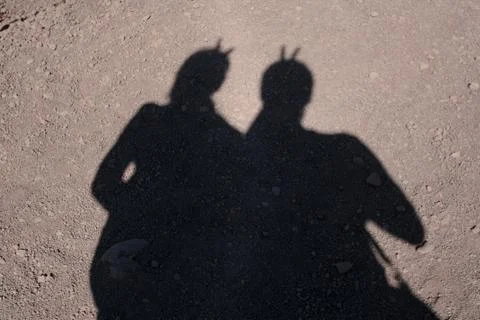 Two shadows on the  sandy road Stock Photos