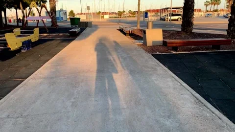 Two shadows walking on the concrete path Stock Footage 131476177