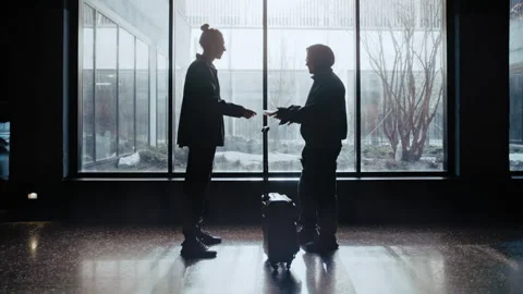 Two Shadowy Figures Exchange Suitcase for Envelope of Money Between Parked Cars Stockbeeldmateriaal 335474482