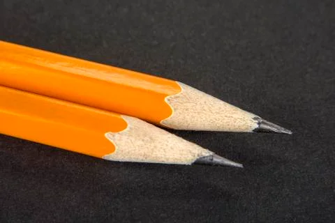Two sharpened pencils on a black background Stock Photos
