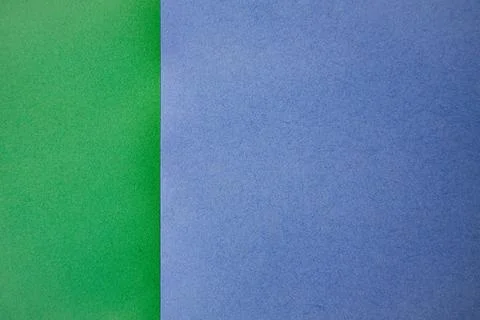 Two sheets of colored paper, one green and one blue, placed side by side on.. Stock Photos