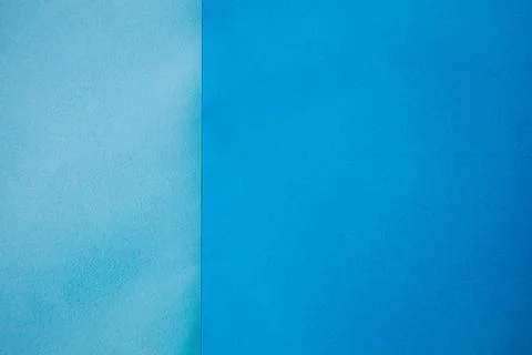 Two sheets of textured paper in gradient shades of blue, one light blue on .. Stock Photos