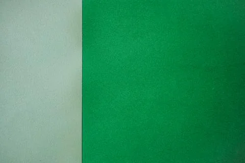 Two sheets of textured paper, one light gray and one vibrant green, placed .. Stock Photos