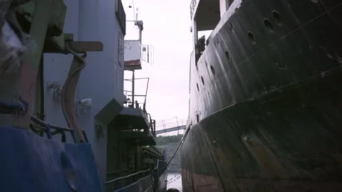 Two ships stand next to a small gap in the port. Footage. Gray ladder between. Stock-Footage 137868295
