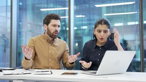 Two shocked stressed co-workers, a man and woman read bad news on laptop  Stock Footage 309011470