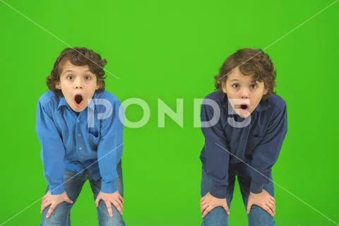 The two shocked twin kids gesture on the green background Stock Photos