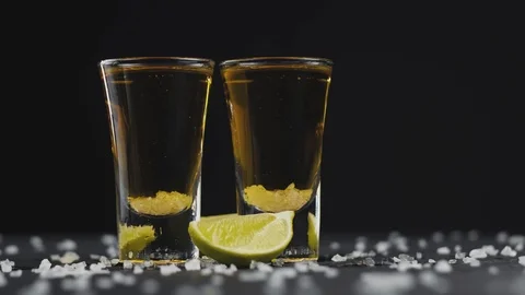 Two shot of gold tequila with lime and salt on a black background. Close-up shot Stock Footage 120194108