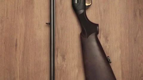 Two shotguns of 16 and 12 gauge and cartridges on camouflage background Stock Footage 101023192