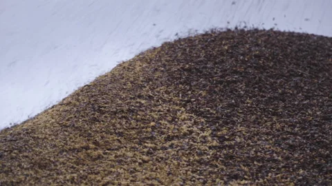 Two shots of different angles of coffee peel falling into waste hill Video stock 163339881