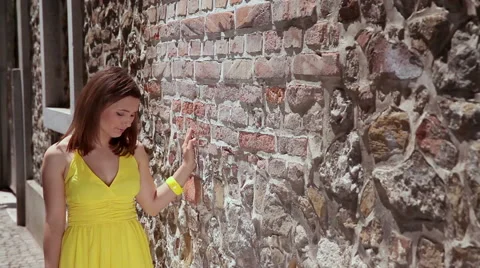 Two shots of young sad and happy woman walking by the brick wall. Stock Footage 49480487