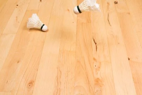 Two shuttlecocks on gym floor Stock Photos