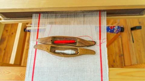 Two shuttles and spools with red and white strings for the loom on a homespun Stock Photos