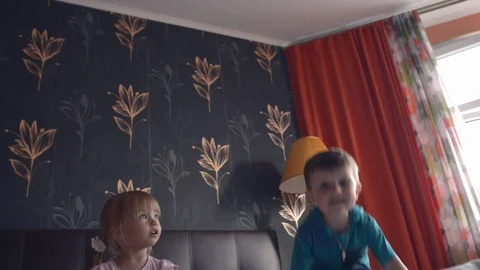 Two siblings jumping on double size bed Stock Footage 124271365