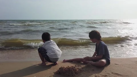 Two Siblings is playing with sand and wave on the Beach of Pattaya, Thailand. Stock Footage 148377249