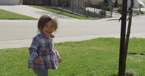 Two siblings, playing together spraying water in the yard, shot on RED EPIC Stock Footage 105376716