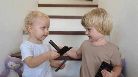 Two siblings sharing and feeding each other with chocolate bars enjoying Stock Footage 168569165