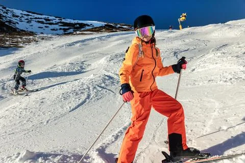 Two siblings ski on bright mountain slope in colorful winter gear, helmets,.. Fotos Stock