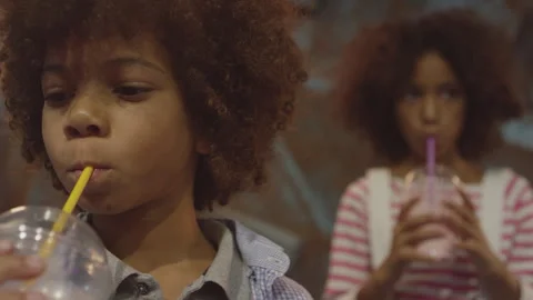 Two siblings slurping some juice Stock Footage 283267021