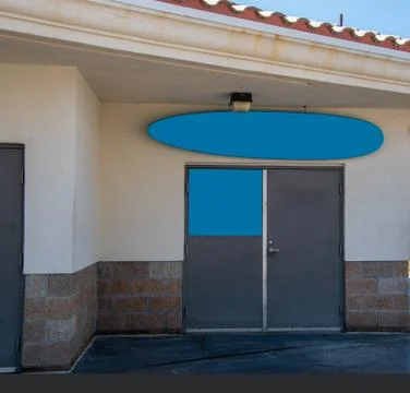 Two signs on a building. One is in the shape of a surfboard Stock Photos