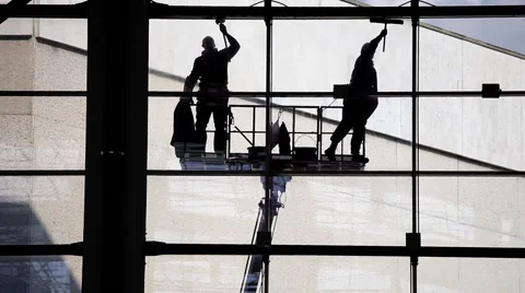 Two silhouette washers washing windows. Industrial facade cleaning Stock Footage 58773996