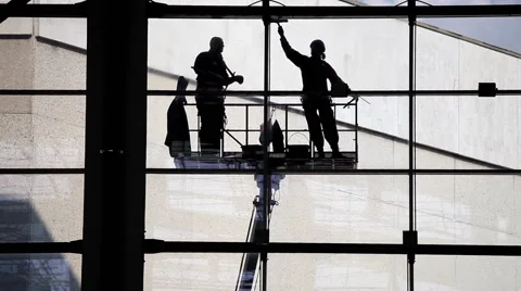 Two silhouette washers washing windows. Industrial climbers Stock Footage 58774008