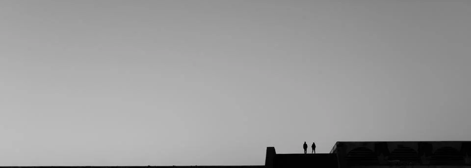 Two silhouettes on rooftop Stock Photos