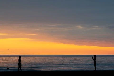 Two silhouettes on the seashore during sunset Foto stock