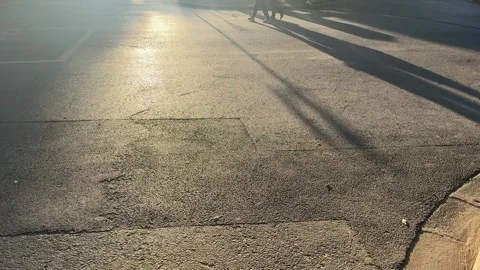 Two Silhouettes Walking with Long Shadows in Sunset Light Stock Footage 331763105