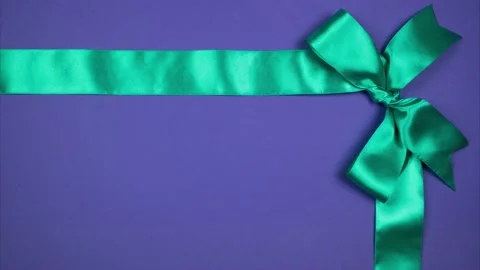 Two silk ribbons form a bow in the corner. Festive background for advertising Stock Footage 144280585