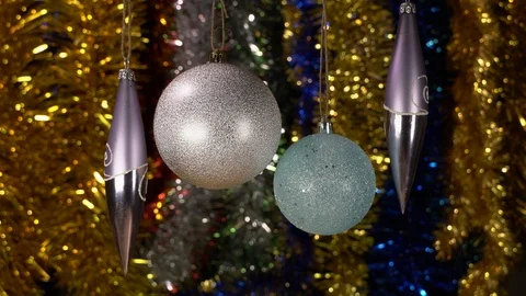 Two silver balls and two glass icicles hanging on a Christmas tree Stock Footage 121482274