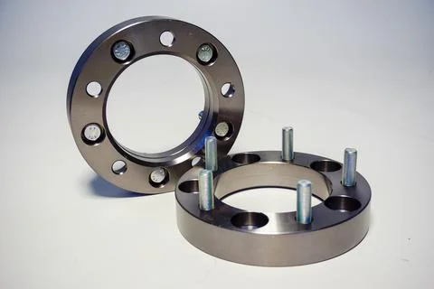 Two silver-colored wheel spacers with multiple bolt patterns are presented .. 写真素材