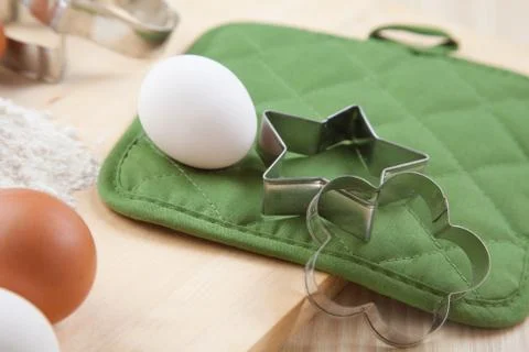 Two silver cookie mold with white egg on wooden table Foto stock