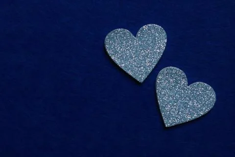 Two silver hearts  on blue background in trendy color of year 2020. Copy spac Stock Photos
